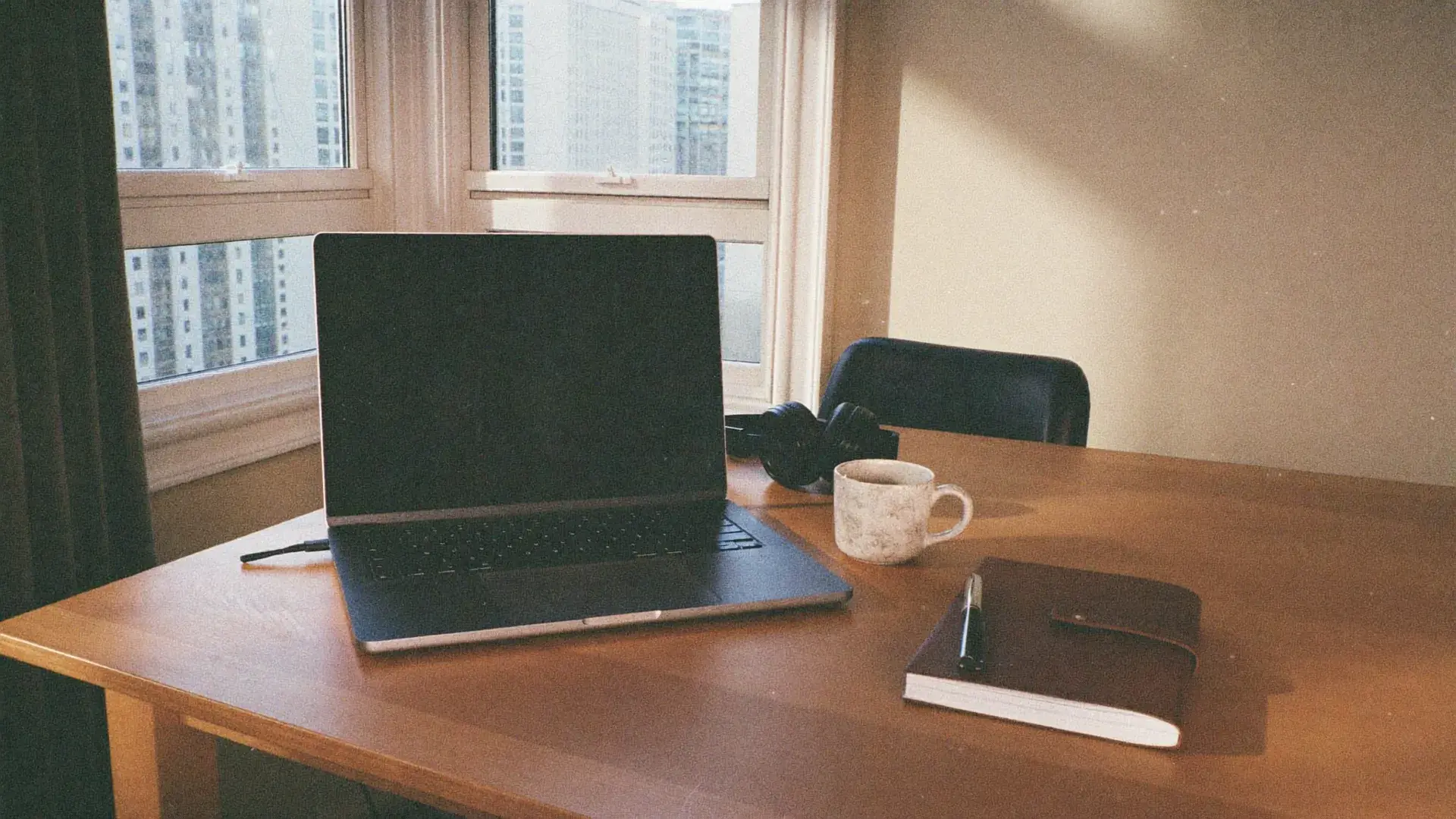 A calm, ordered workspace by a tall sash window in warm morning light
