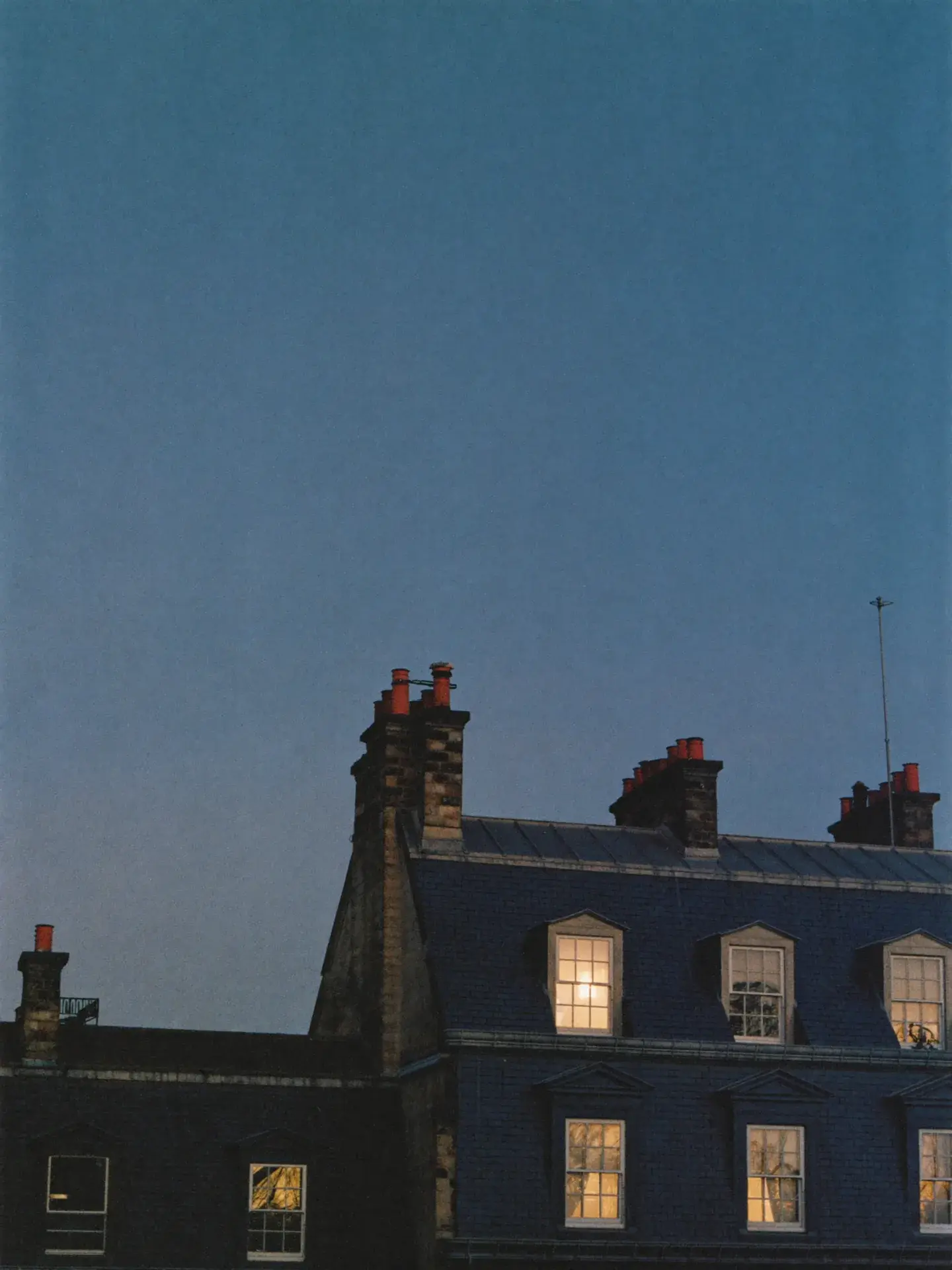 London rooftops at dusk, scattered windows glowing warm against deep navy