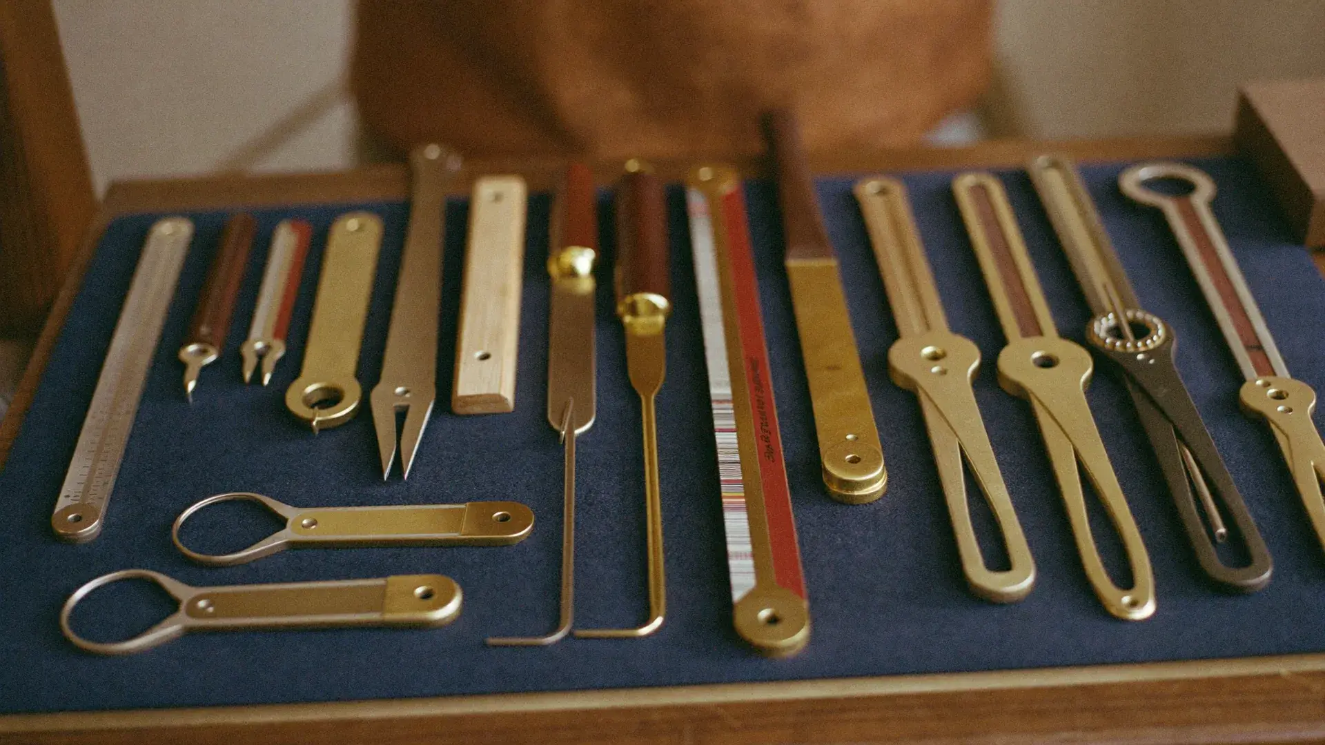 Precision hand tools laid out in perfect order on a deep navy felt mat